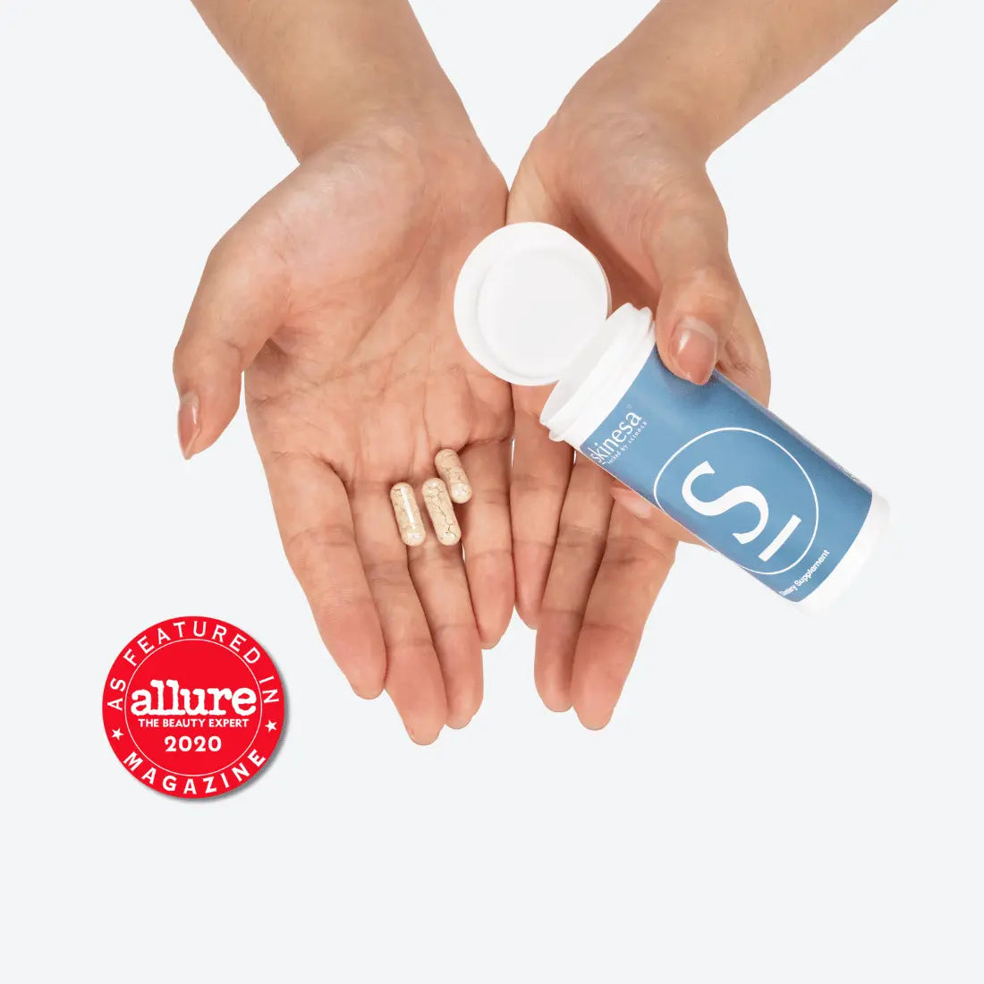hand holding skinesa bottle with capsules